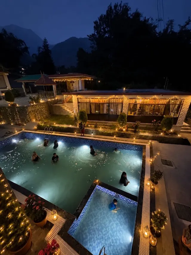 The pool and lawn lit up at night