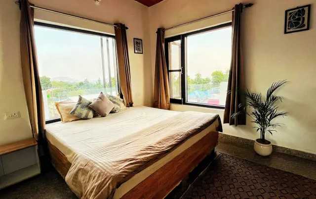Bedroom with a queen bed and windows on two sides