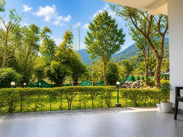 Lawn and trees with the Dhauladhar range behind, seen from the veranda at The Pahaadhi